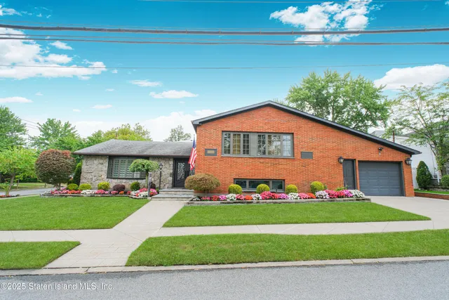 a front view of a house with a yard garage and outdoor seating