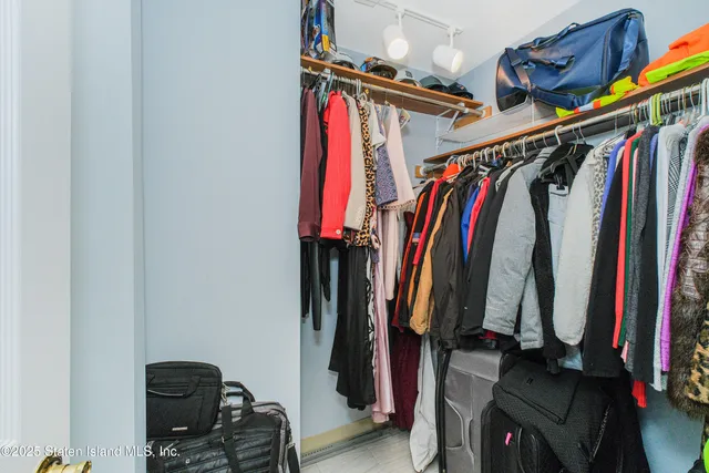 a view of walk in closet with clothes