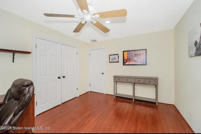 a view of room with wooden floor and ceiling fan