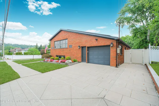 a front view of a house with yard and large trees
