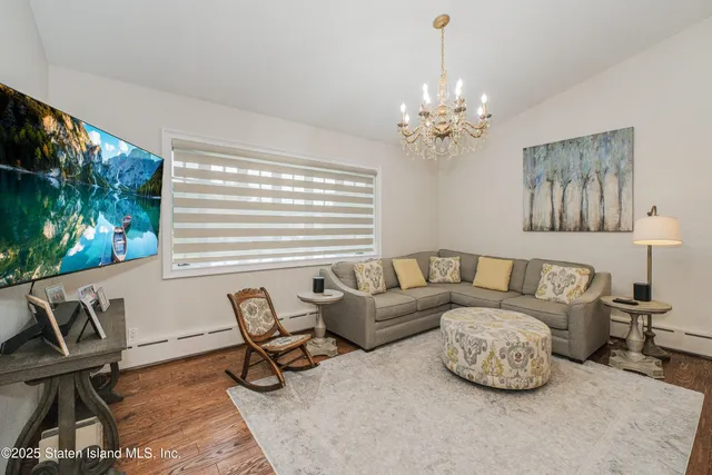 a living room with furniture a chandelier and a window