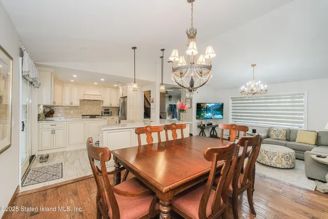 a view of a dining room with furniture wooden floor and chandelier