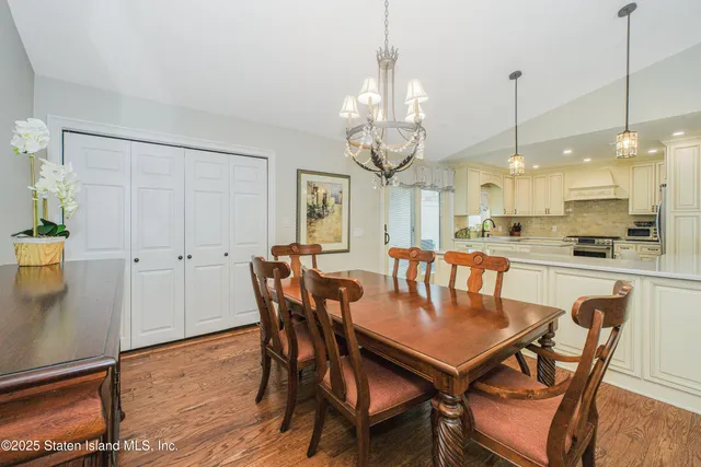 a view of a dining room and livingroom with furniture wooden floor a chandelier