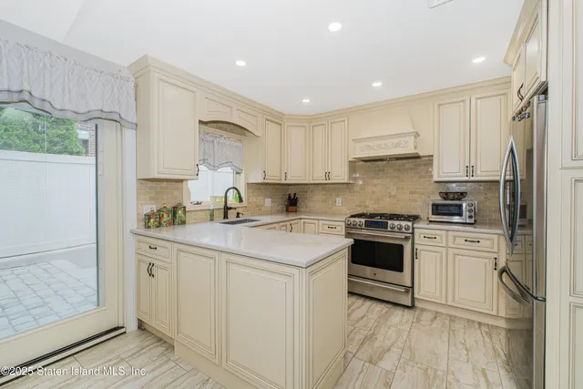 a kitchen with stainless steel appliances granite countertop a sink stove and refrigerator