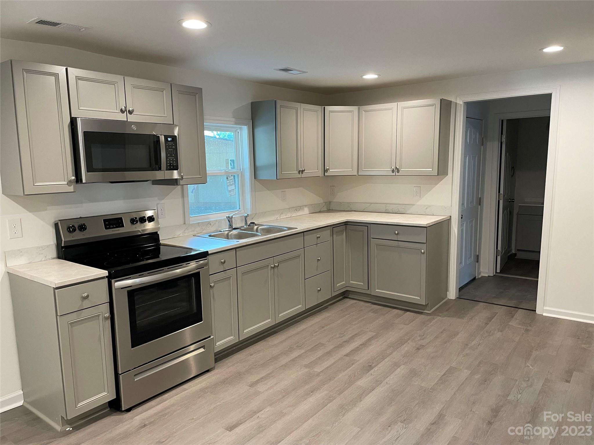 205 Jerome Street Wingate, NC 28174 - Photo 4 of 7 a kitchen with stainless steel appliances granite countertop a stove a sink and a microwave