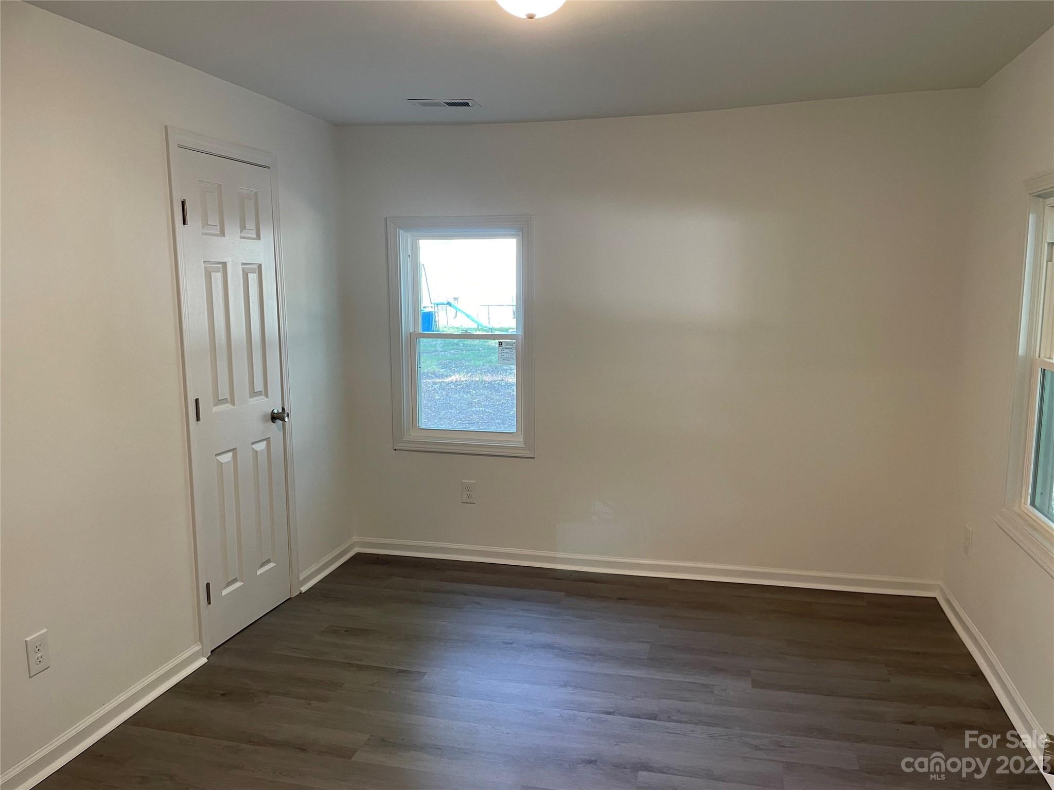 205 Jerome Street Wingate, NC 28174 - Photo 6 of 7 a view of an empty room with wooden floor and a window