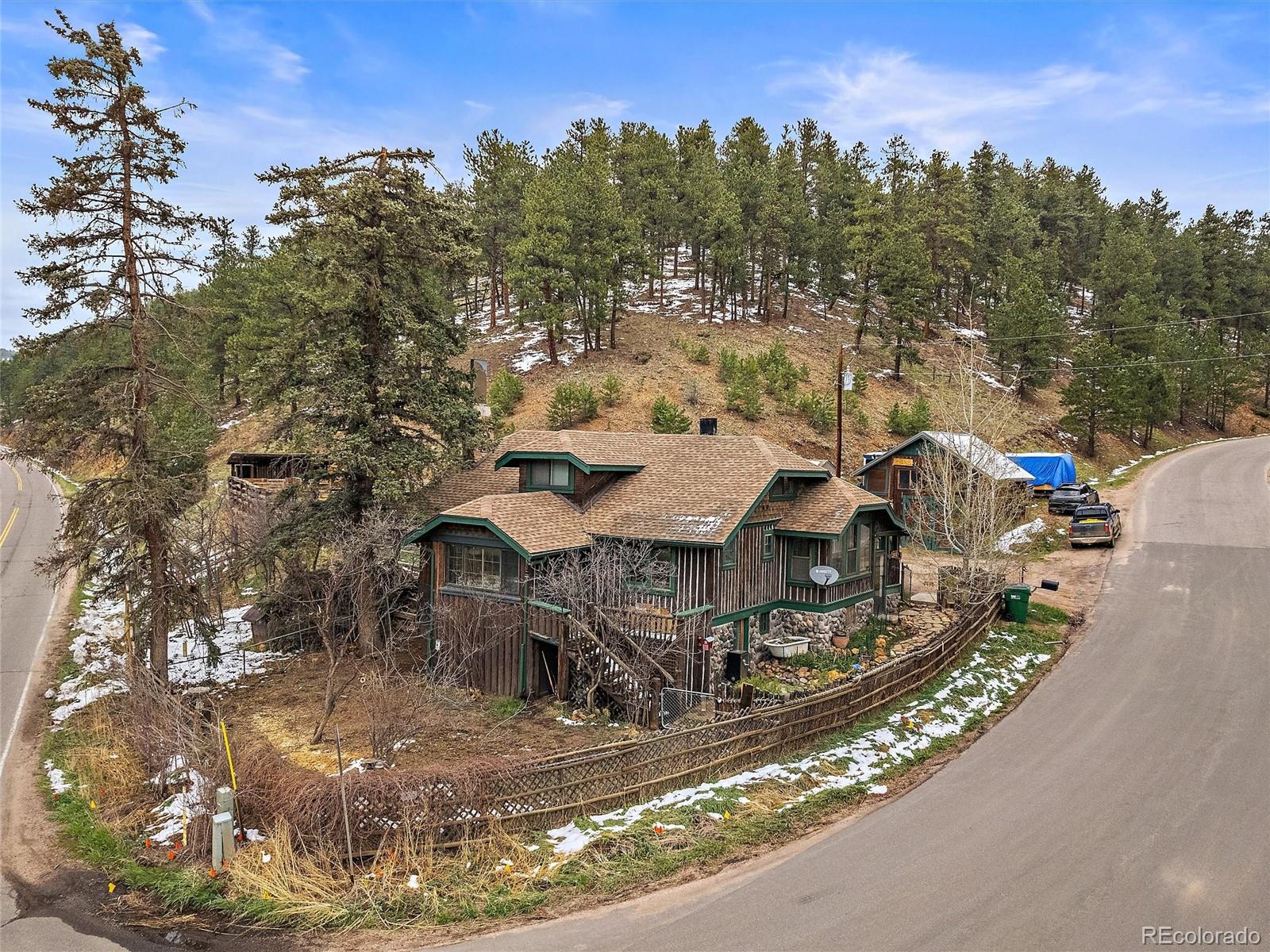 24293 Running Deer Road Conifer, CO 80433 - Photo 1 of 33 a view of a house with a yard and sitting area