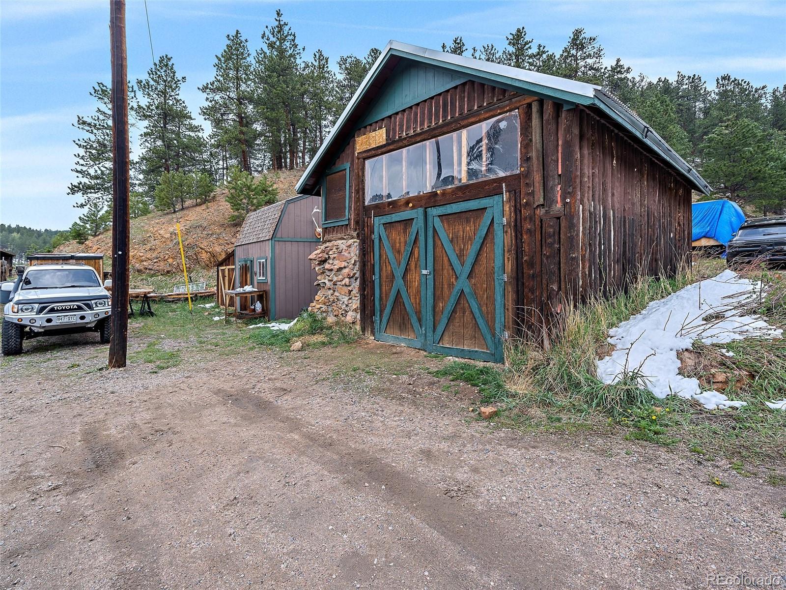 24293 Running Deer Road Conifer, CO 80433 - Photo 27 of 33 a view of a house with a yard and parking space