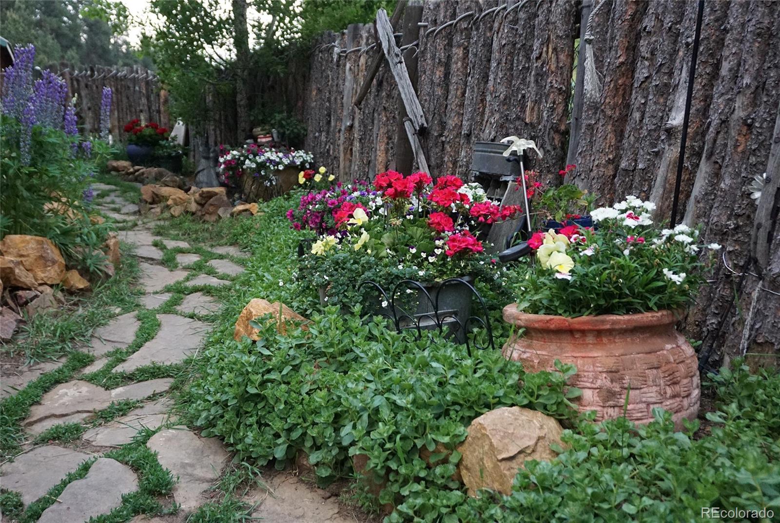 24293 Running Deer Road Conifer, CO 80433 - Photo 4 of 33 a view of a garden with flowers