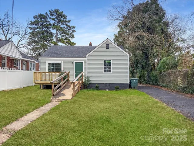 a view of a house with a yard and trees
