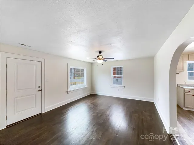 a view of a big room with wooden floor and windows in a room