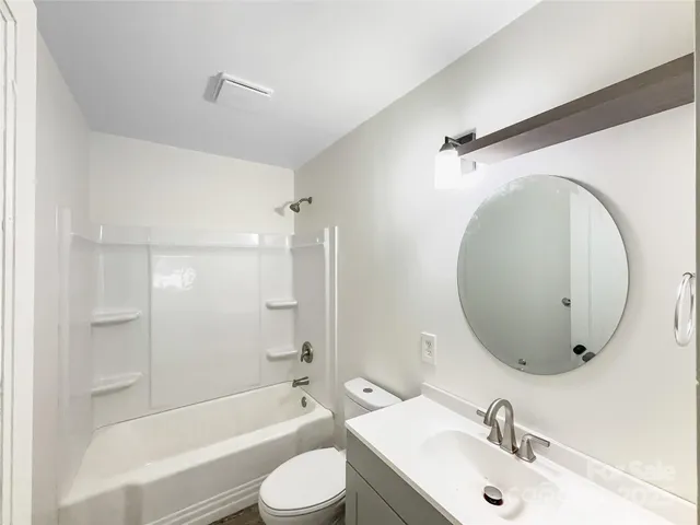 a bathroom with a sink mirror toilet and bathtub