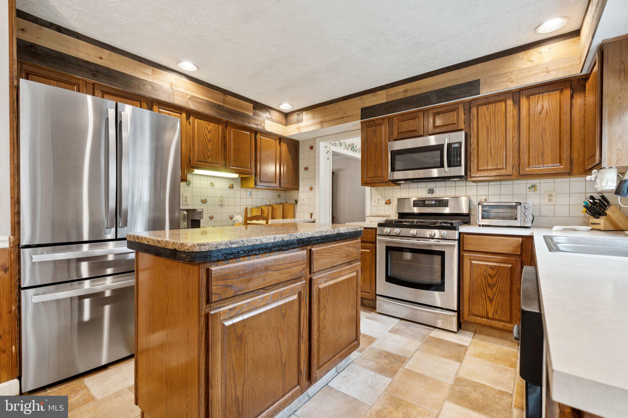 817 Peppard Drive Bel Air, MD 21014 - Photo 12 of 49 a kitchen with stainless steel appliances granite countertop a stove a sink and a refrigerator