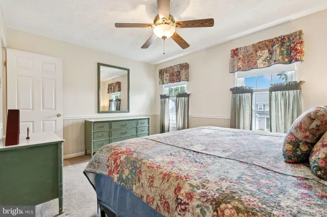 a bedroom with a bed dresser and a large window