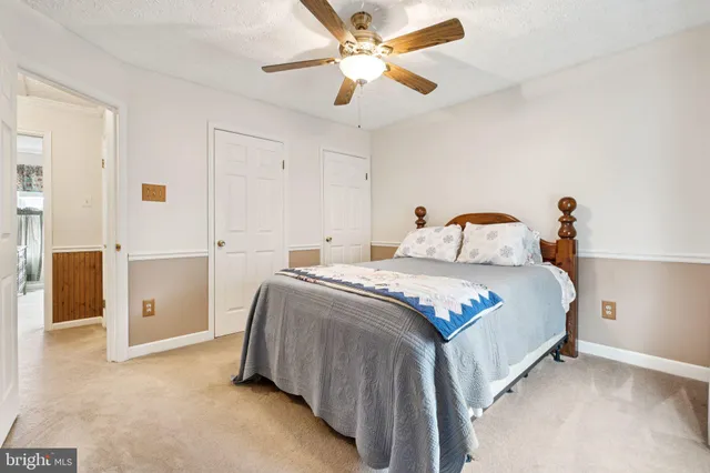 a bedroom with a bed and a ceiling fan
