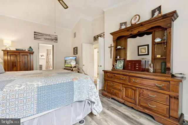 a bedroom with a bed and a flat tv screen on dresser