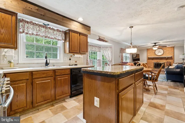 a kitchen with stainless steel appliances granite countertop sink stove and large window