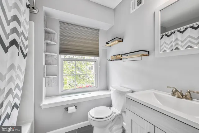 a bathroom with a sink a toilet and a window