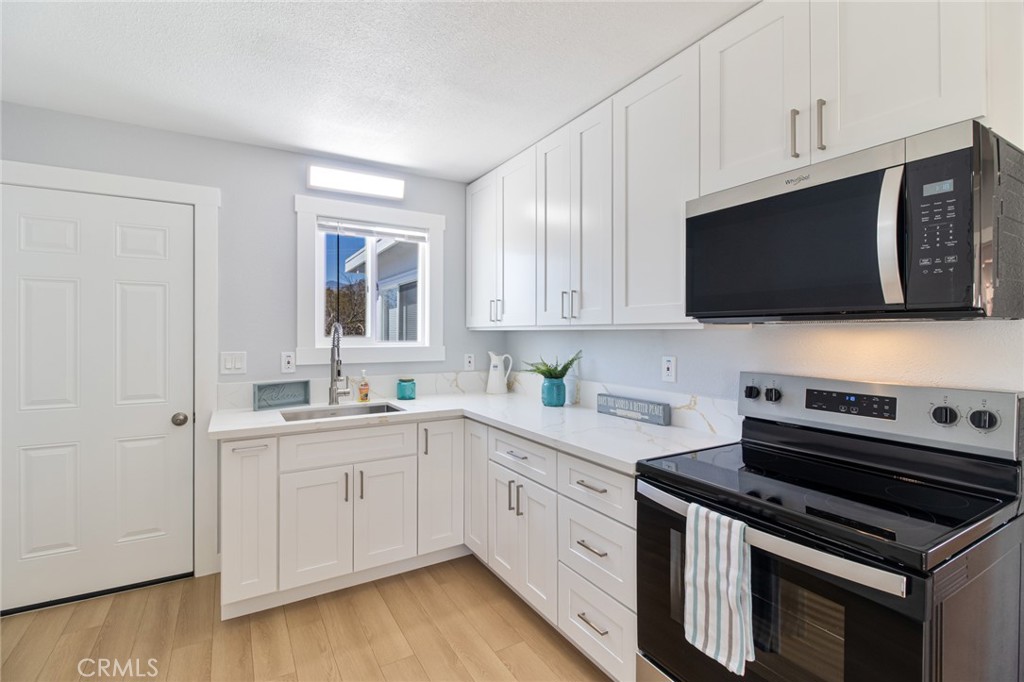 a kitchen with a sink stove and microwave