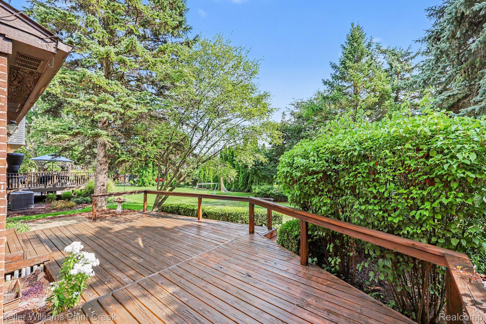 2717 Powderhorn Ridge Road Rochester, MI 48309 - Photo 32 of 48 Expansive wood deck with railing overlooking a lush lawn and mature trees