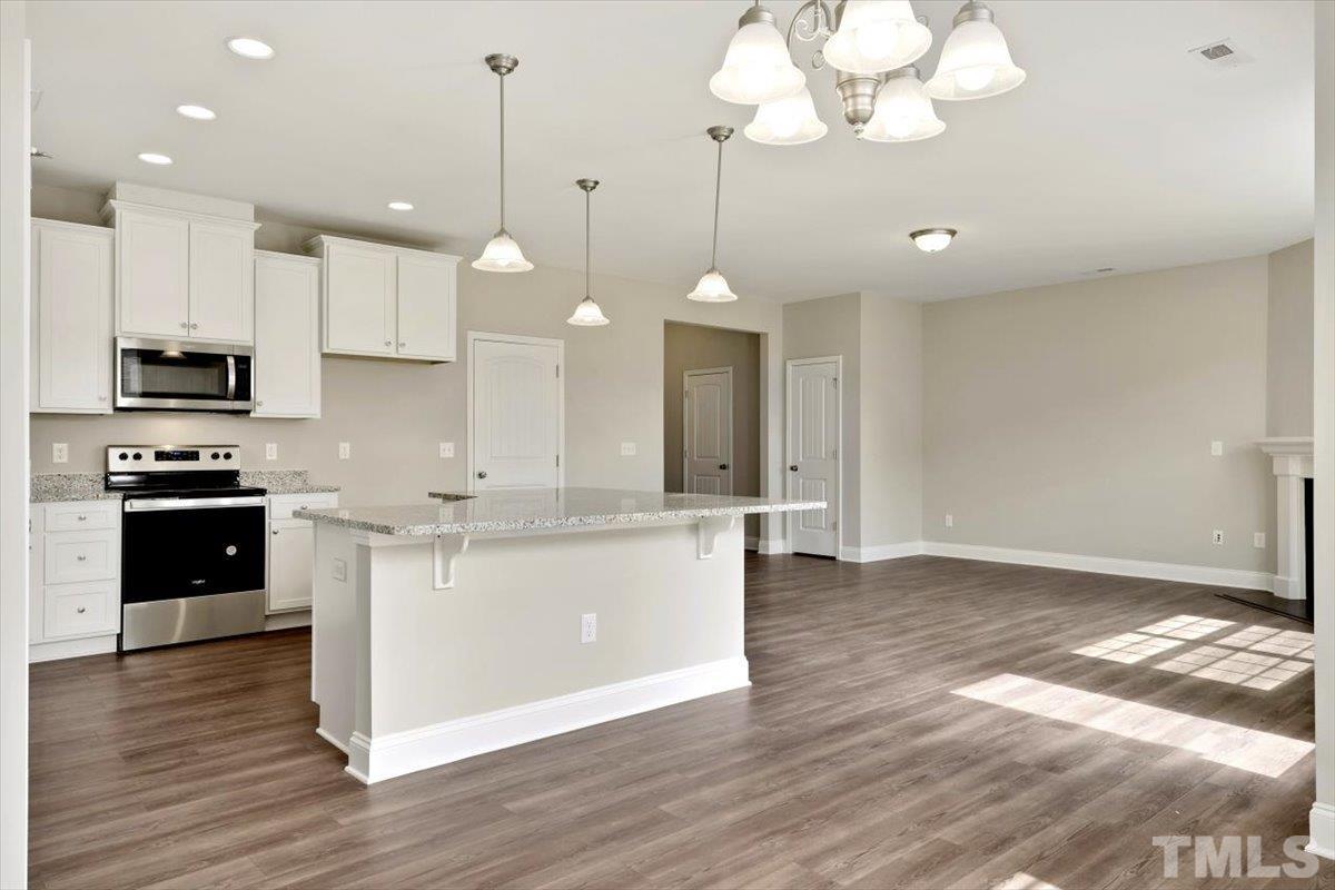 2215 Campbell Loop, Unit 49 Burlington, NC 27215 - Photo 12 of 48 a large kitchen with granite countertop a stove a sink and a wooden floor