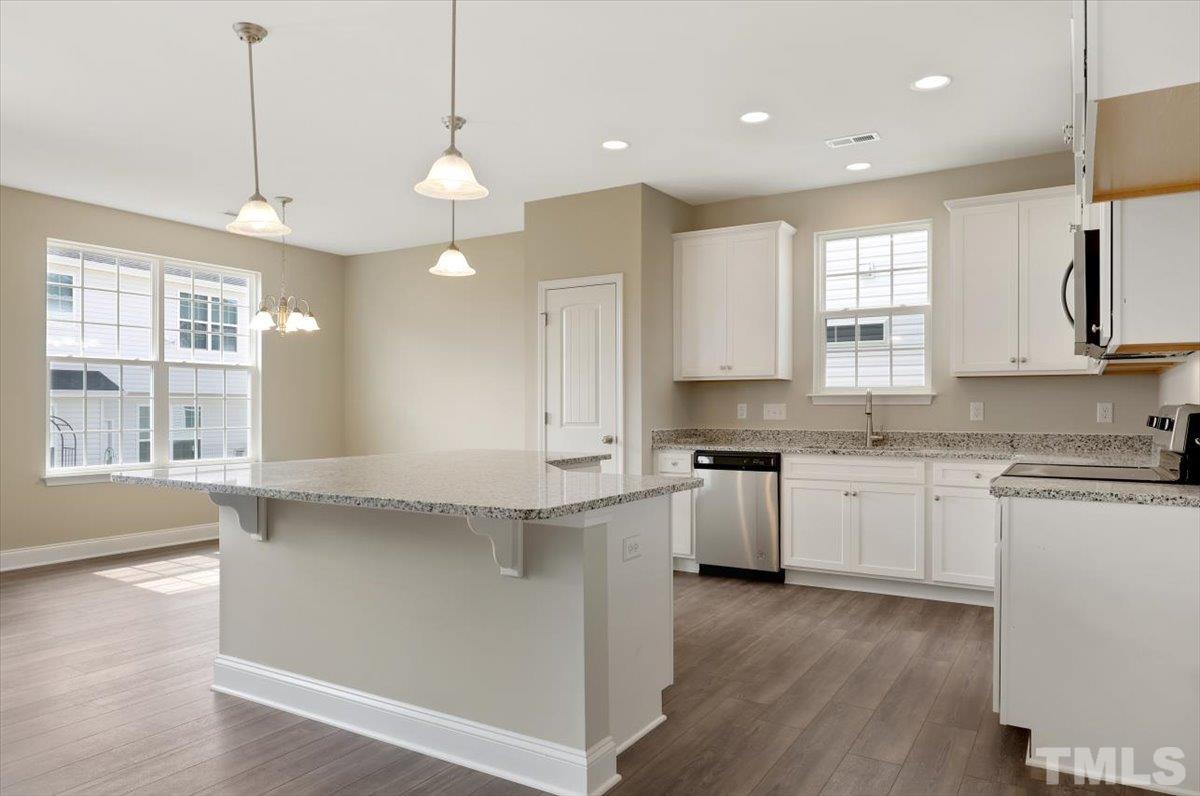 2215 Campbell Loop, Unit 49 Burlington, NC 27215 - Photo 9 of 48 a kitchen with stainless steel appliances granite countertop a sink a stove a refrigerator and island with wooden floor
