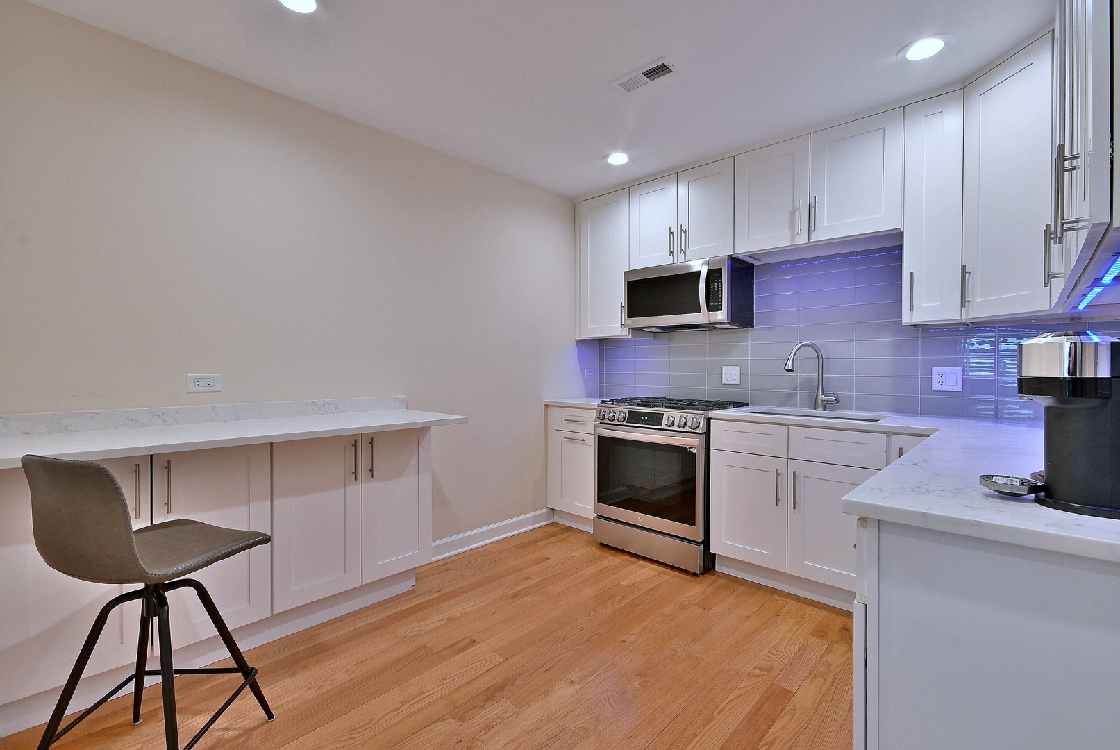 3045 North Paris Avenue, Unit 203 River Grove, IL 60171 - Photo 10 of 27 a kitchen with granite countertop a stove a sink and a microwave
