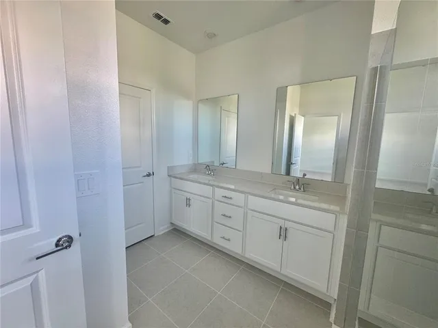 a spacious bathroom with a granite countertop sink a mirror and a