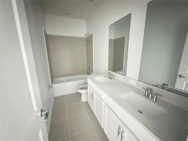 a bathroom with a double vanity sink mirror double and a bathtub