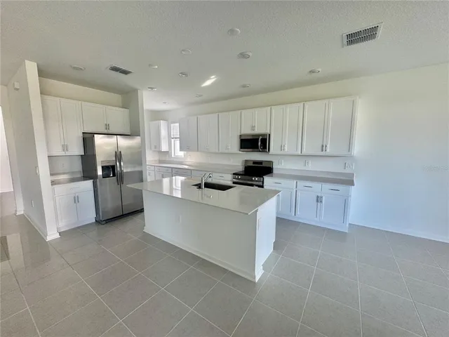 a kitchen with stainless steel appliances a refrigerator sink microwave and cabinets