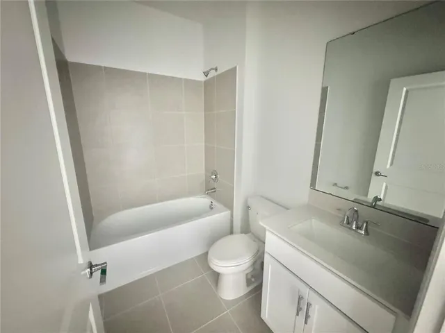 a bathroom with a granite countertop sink a toilet and shower