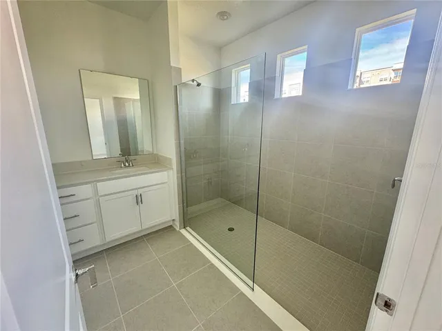 a bathroom with a shower a sink and a mirror
