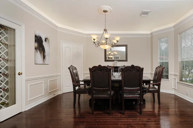 a view of a dining room with furniture a chandelier and wooden floor