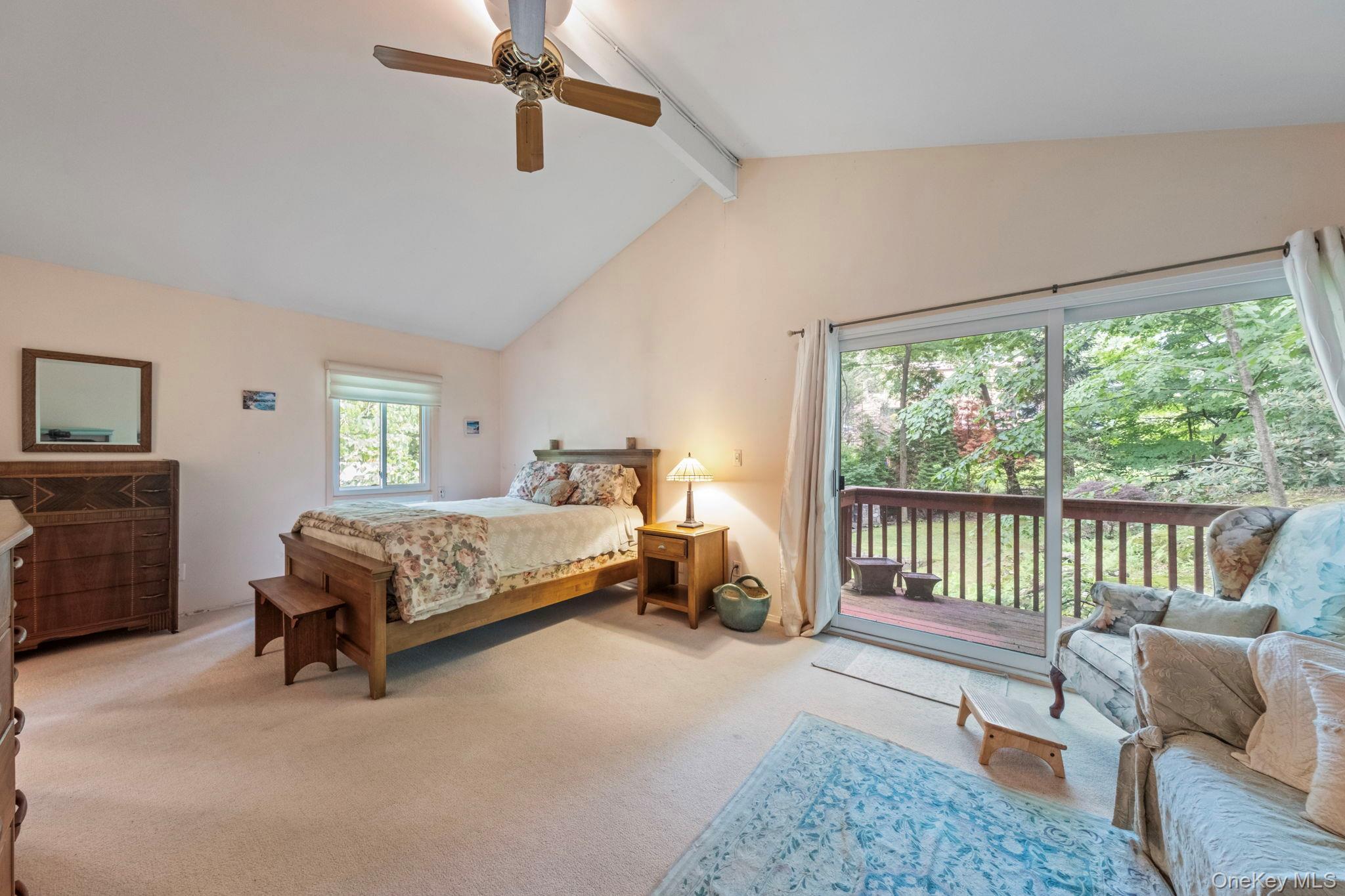 73 Bramblebrook Road Ardsley, NY 10502 - Photo 22 of 35 Vaulted ceiling bedroom with a ceiling fan, plush carpet flooring, a window, and sliding glass doors opening to a wood deck