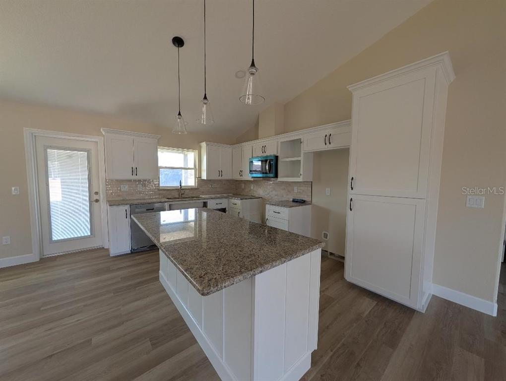 5441 Chestnut Ridge Road Dade City, FL 33523 - Photo 15 of 27 a kitchen with stainless steel appliances granite countertop a sink a oven a refrigerator and white cabinets