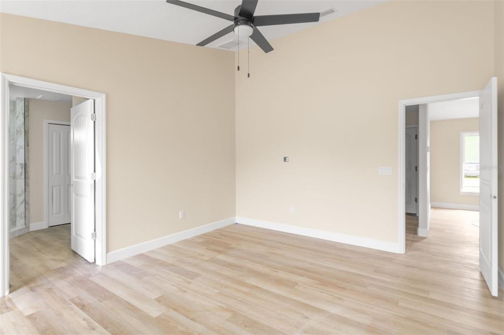 5441 Chestnut Ridge Road Dade City, FL 33523 - Photo 20 of 27 a view of a room with wooden floor and a ceiling fan