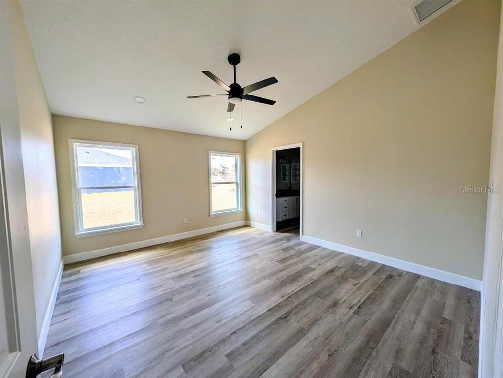 5441 Chestnut Ridge Road Dade City, FL 33523 - Photo 8 of 23 a view of an empty room with a window and wooden floor