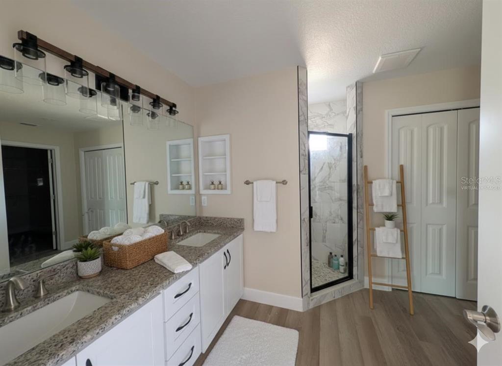 5441 Chestnut Ridge Road Dade City, FL 33523 - Photo 10 of 27 a spacious bathroom with a granite countertop sink mirror and shower