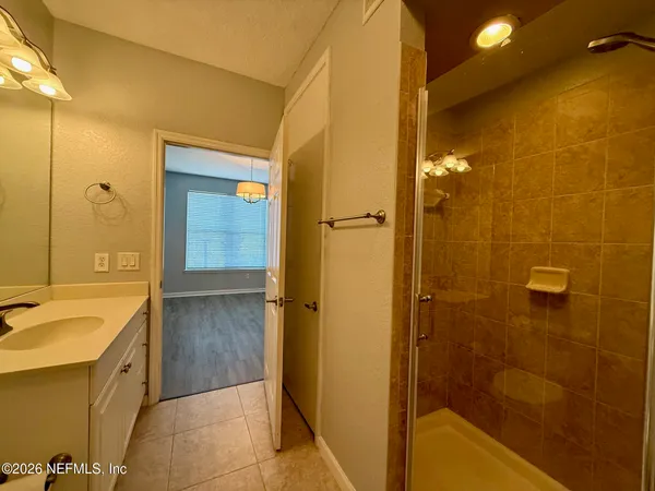 a bathroom with a tub sink shower and a mirror