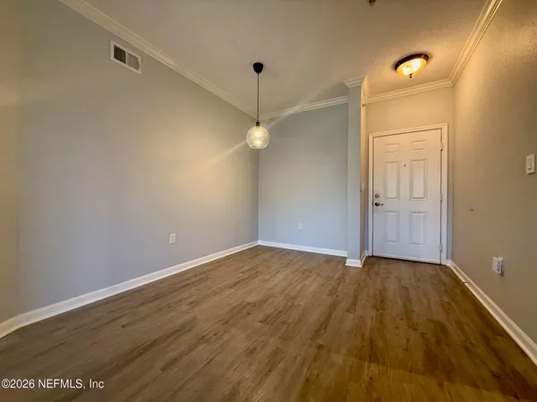 a view of an empty room with wooden floor