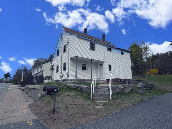 a view of a house with a yard and sitting area