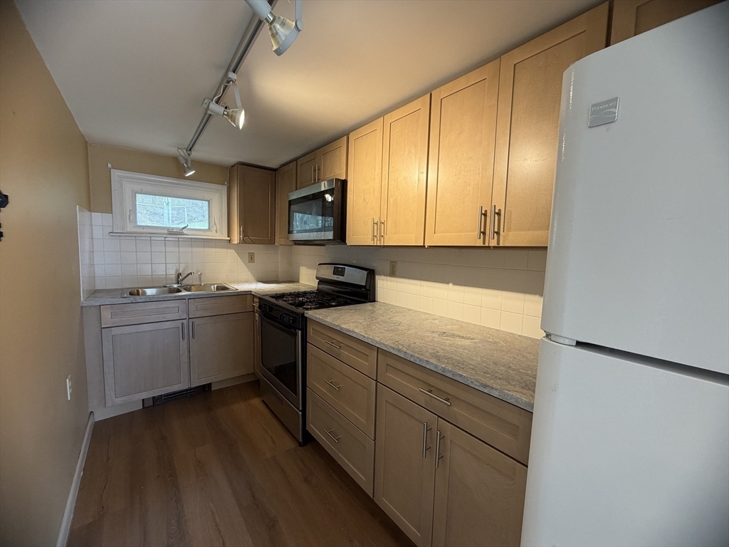 79 North Main Street, Unit A Bellingham, MA 02019 - Photo 11 of 22 a kitchen with a sink cabinets and wooden floor