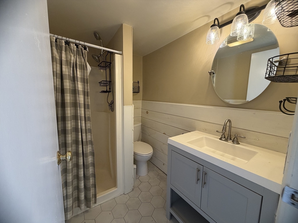 79 North Main Street, Unit A Bellingham, MA 02019 - Photo 12 of 22 a bathroom with a granite countertop sink toilet and shower
