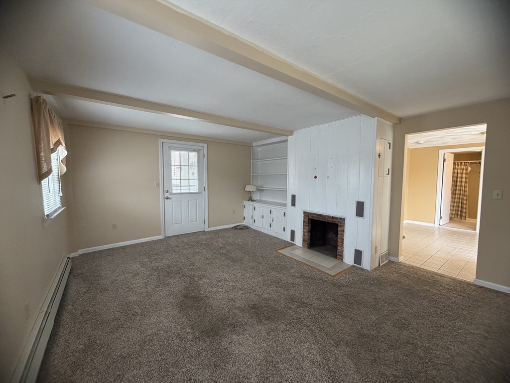 79 North Main Street, Unit A Bellingham, MA 02019 - Photo 15 of 22 an empty room with windows and fireplace
