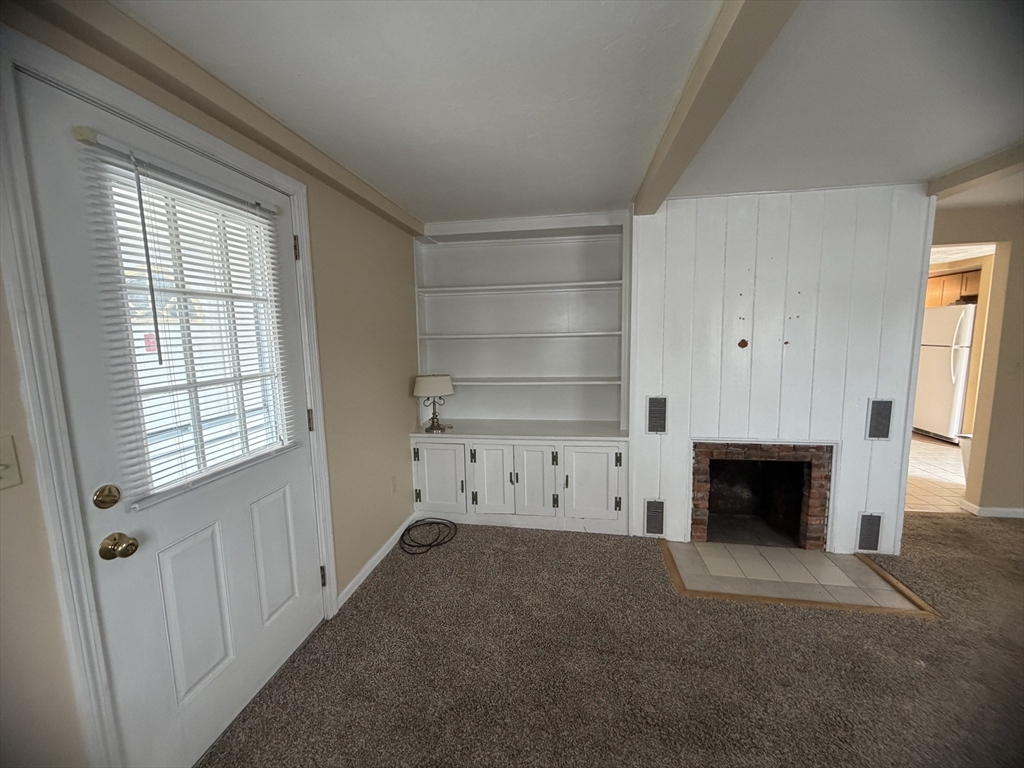 79 North Main Street, Unit A Bellingham, MA 02019 - Photo 16 of 22 a view of a livingroom with an empty space and a fireplace