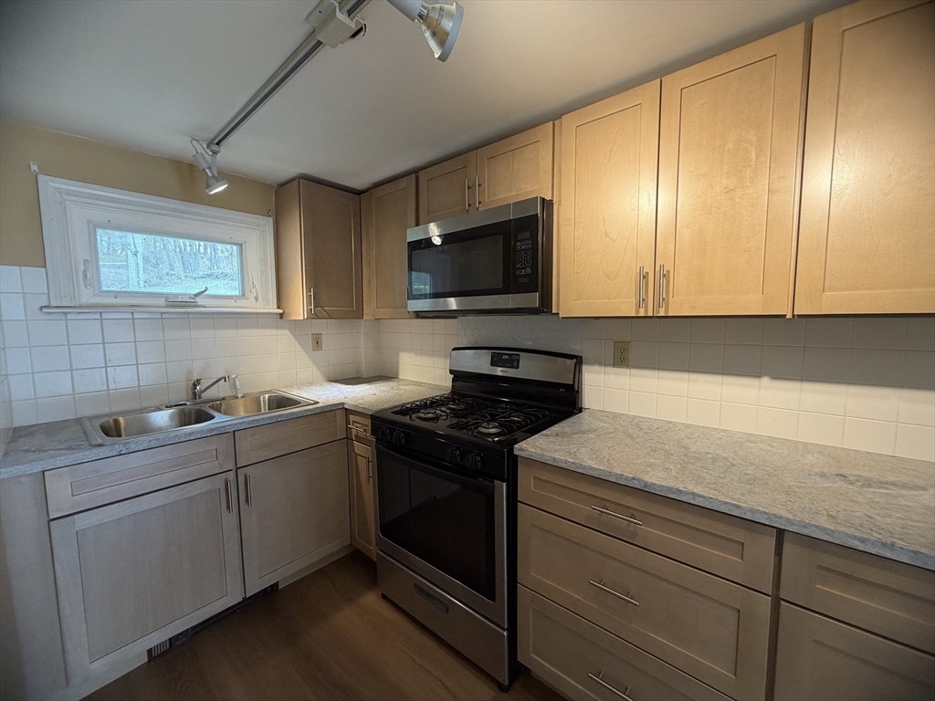 79 North Main Street, Unit A Bellingham, MA 02019 - Photo 17 of 22 a kitchen with stainless steel appliances granite countertop a sink and a stove