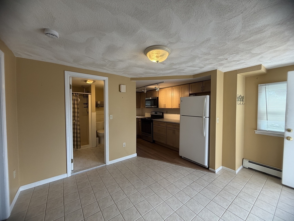 79 North Main Street, Unit A Bellingham, MA 02019 - Photo 6 of 22 a view of a kitchen with a sink and a refrigerator