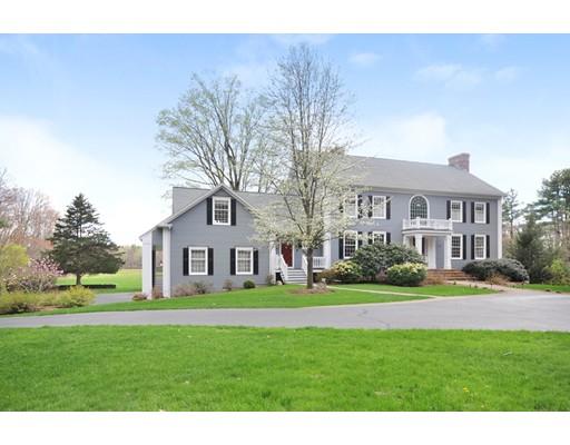a front view of a house with a garden and trees