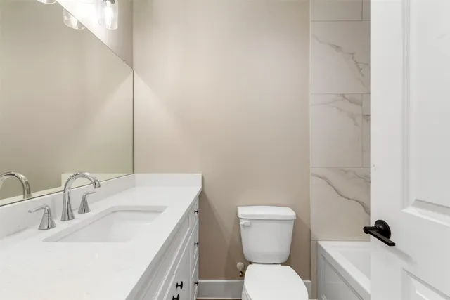a bathroom with a toilet sink and mirror