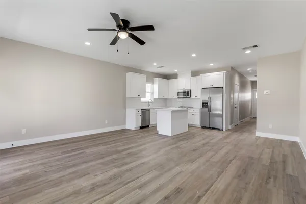 a view of kitchen with stainless steel appliances refrigerator stove microwave and cabinets
